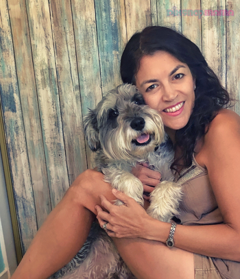 Pix Snap Mama sitting and hugging her beloved Schnauzer in front of a faded wood backdrop. Dog photo shoot finished.