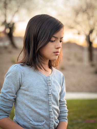 iPhone portraits of a dark haired girl in gray long sleeve top standing on grass with trees and rocks behind at sunset.. Pix Snap Mama is overlaid in the lower right corner